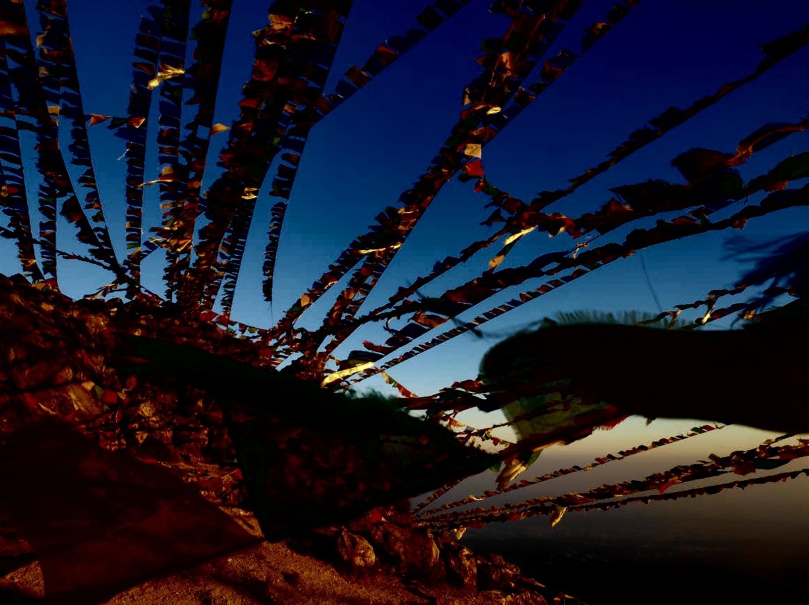 Colorful prayer flags stretching across the evening sky.