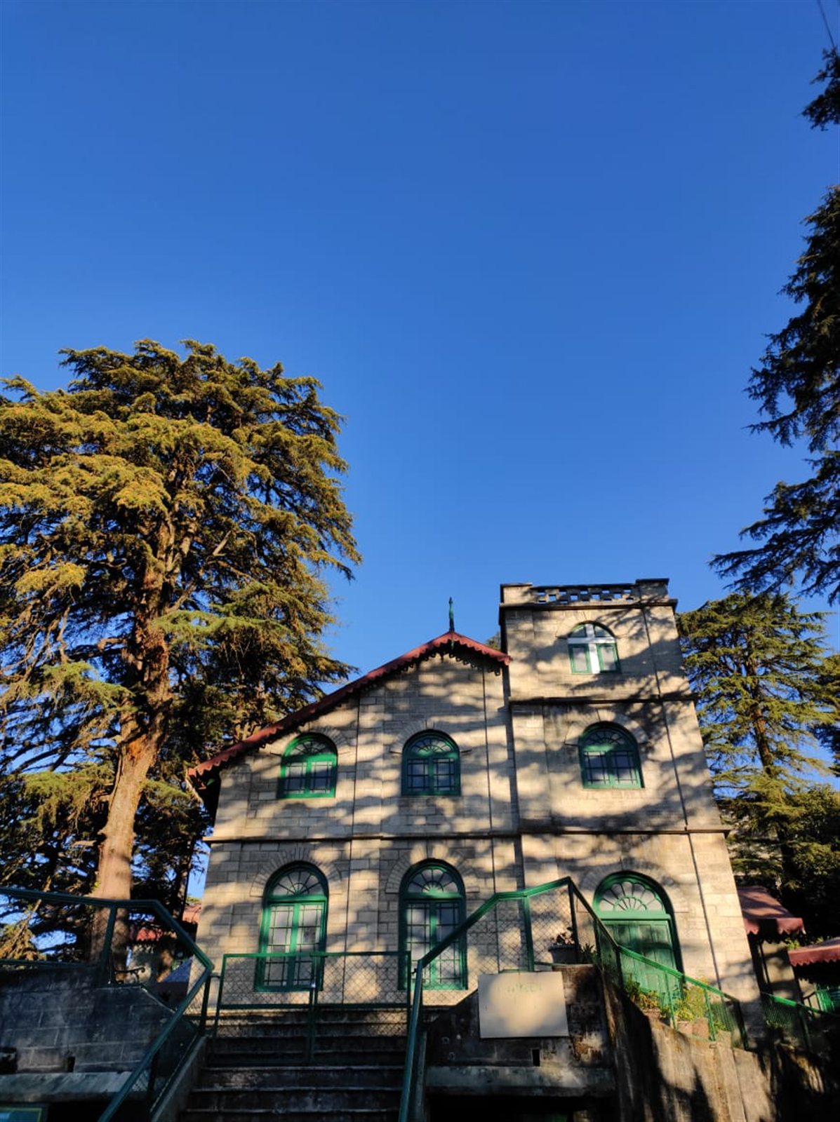 Kellogg Memorial Church framed by tall trees and blue sky.